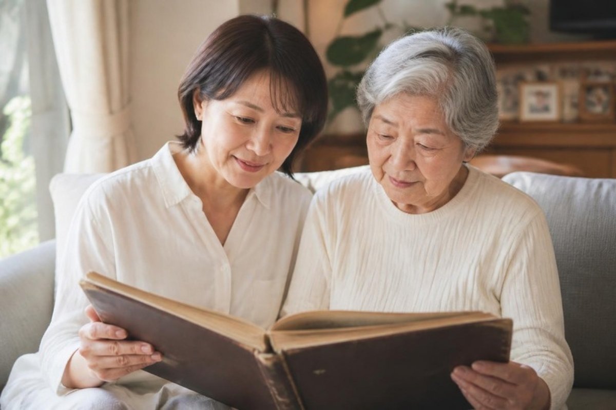 年配の母と並んで古いアルバムを見る娘