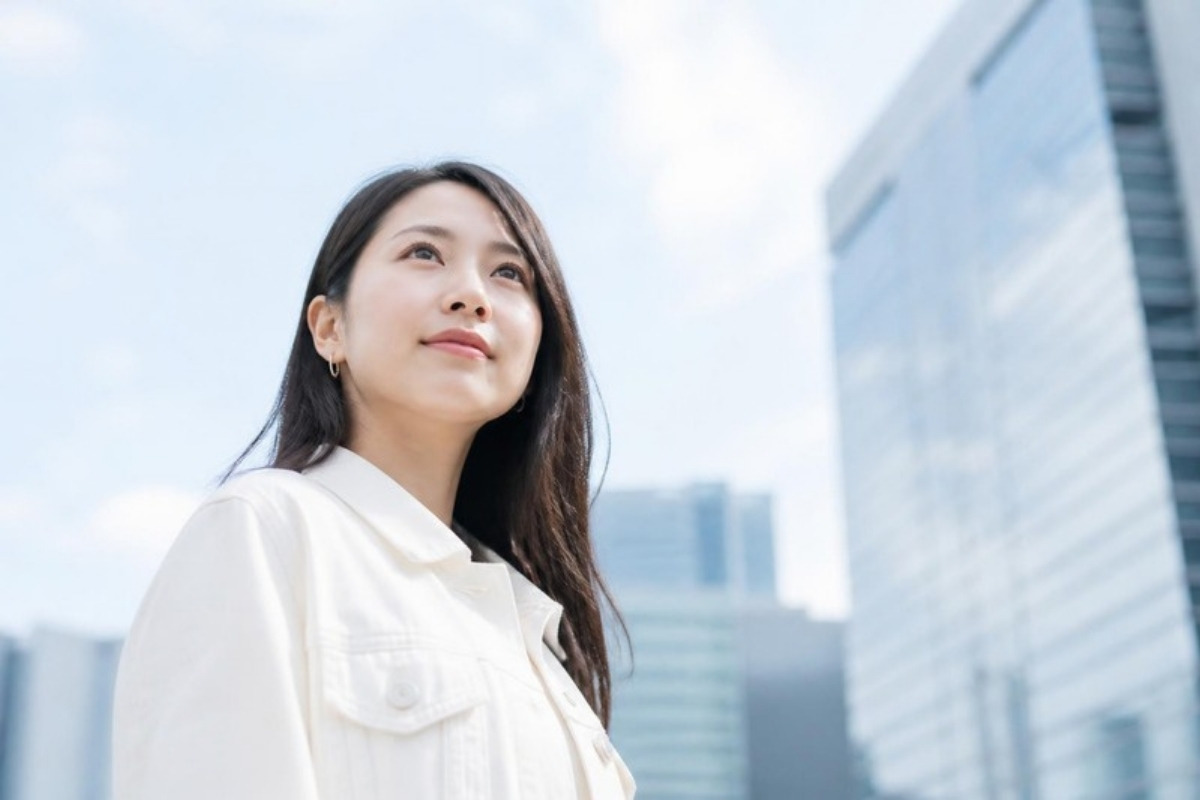 感情の整理を終えて、明るい街並みで顔を上げ前を見つめる女性