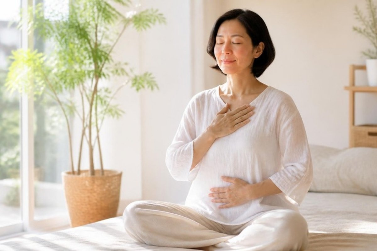 胸とおなかに手を当て、からだと心を感じながら呼吸する女性
