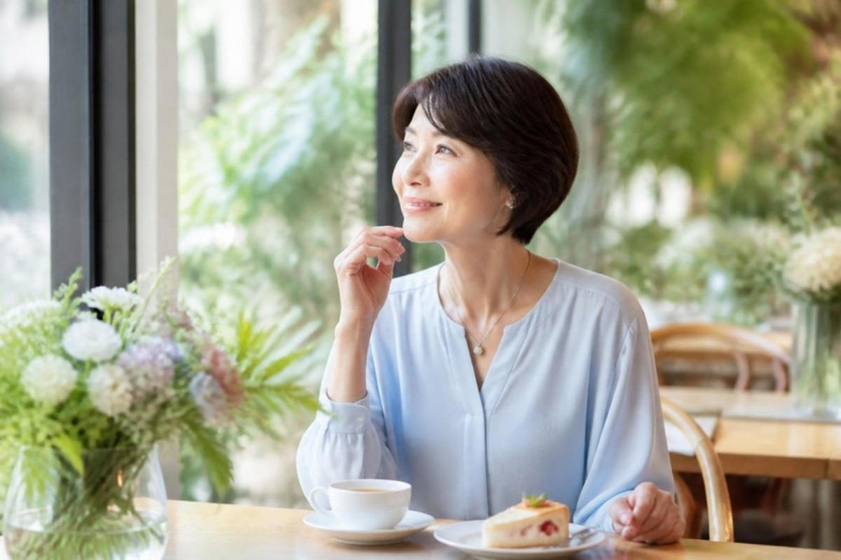 花のあふれるカフェで、自分の時間を楽しむおしゃれな女性