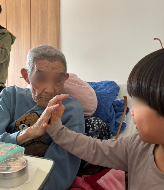 海外に住む孫が会いに来て、手を合わせる義父(目元はぼかしています)