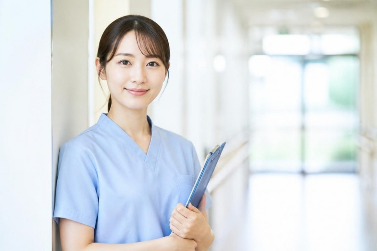 クリップボードを持ち、やさしくほほえむ看護師のイメージ