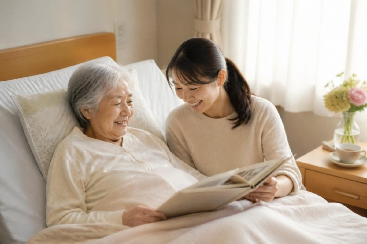 病室で、母と娘がアルバムを見ながら笑い合う